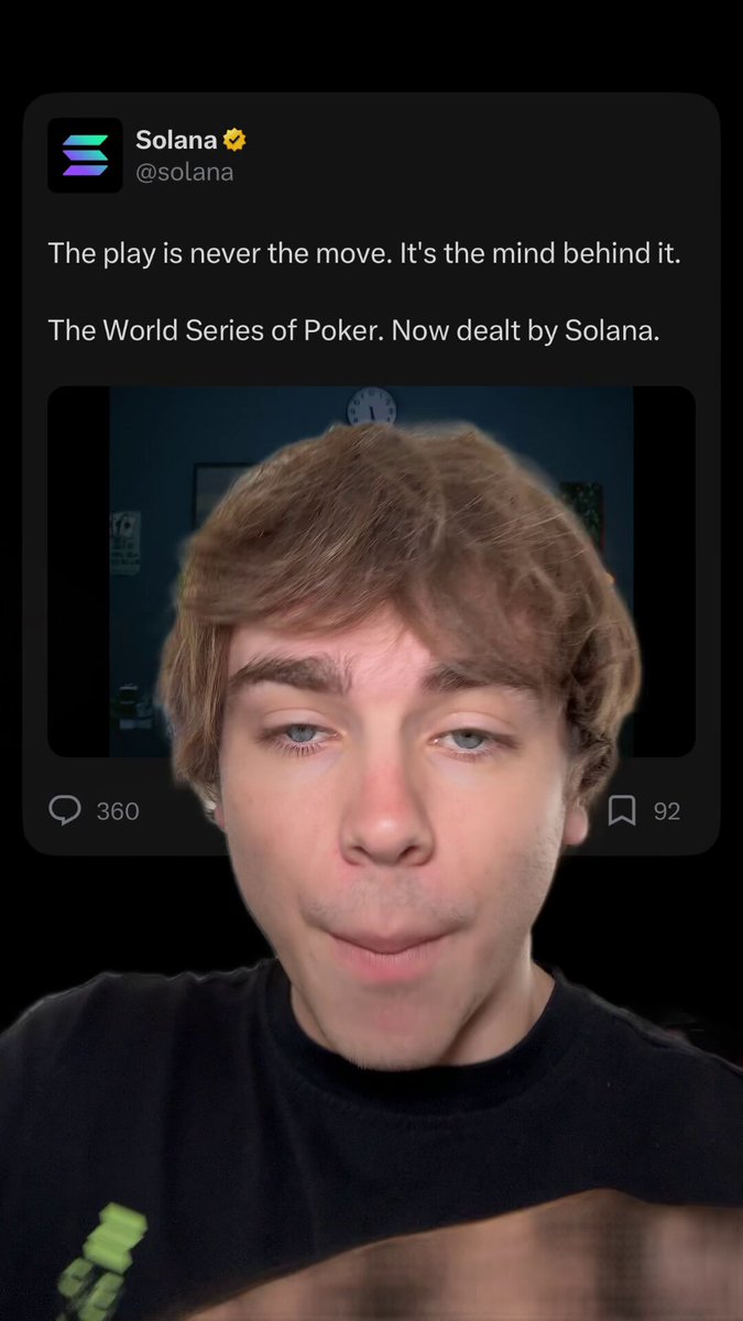 The image features a young man with short hair wearing a black shirt, who appears to be smiling at the camera. The background of the photo shows a dark room or office setting, which contrasts with the bright screen displaying the text "The play is never the move. It's the mind behind it." and "The World Series of Poker. Now by Solana". This suggests that the image might have been taken during an online poker game or event sponsored by Solana, a cryptocurrency platform. The post encourages players to enter the WSOP immediately after entering their name in the comment section below the photo.