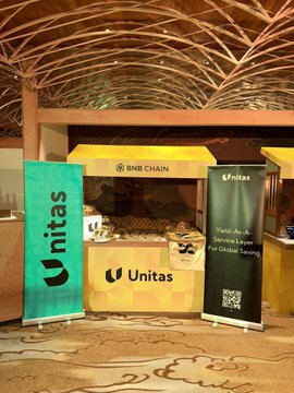 A photo of an Unitas and BNB Chain booth, likely at a crypto or blockchain conference, featuring a sign reading "Yield As A Service to Empower Web3 For Global Saving."