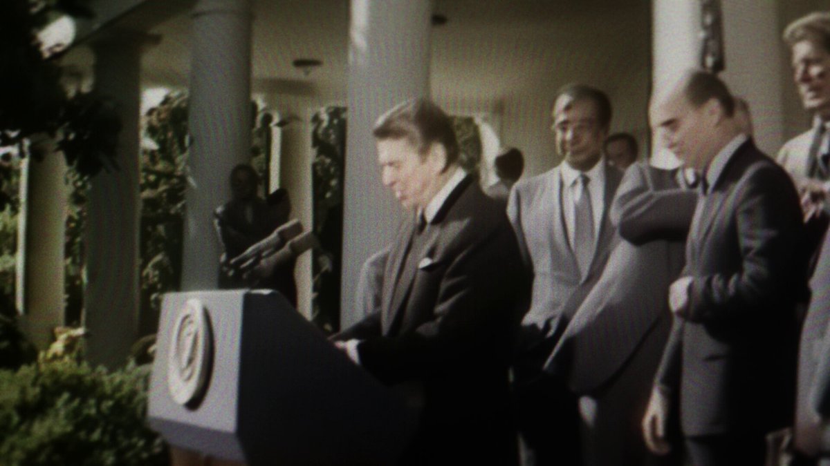The image shows a man standing at a podium, giving a speech or addressing an audience. The setting appears to be outdoors with a white building visible behind him. There are several people gathered around the speaker, indicating that this could be a significant event or gathering. The image also contains text that reads "1/ For years, qualified custody meant idle capital. Today, that changes. We're partnering with @BitGo to build a custody-native vault platform; institutional assets staying in regulated custody while running strategies through Concrete's vault architecture." This suggests that the speaker is discussing the importance of utilizing vault technology for asset management and security purposes.
