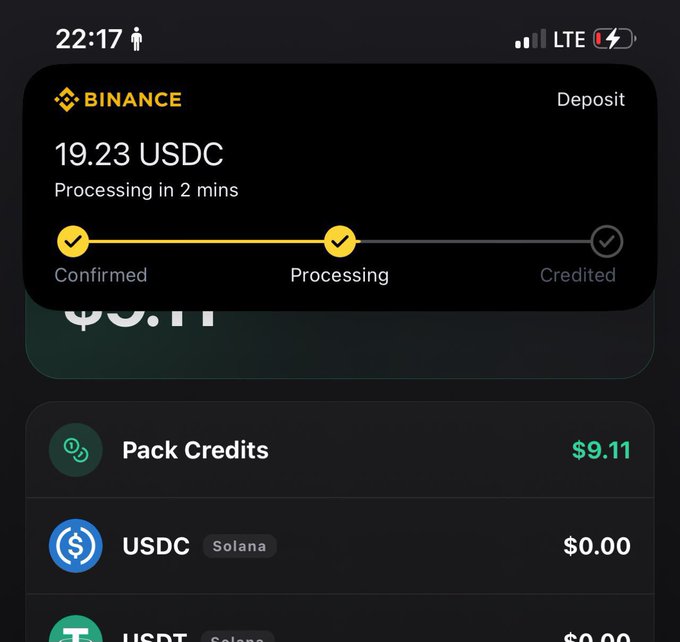 A mobile screenshot shows a Binance app deposit notification for 19.23 USDC currently "Processing" (with confirmed and credited status indicators visible), while the background reveals the Phygitals app wallet containing $9.11 in Pack Credits and $0.00 USDC balances—illustrating the deposit step required to earn the referral bonus mentioned in the post.