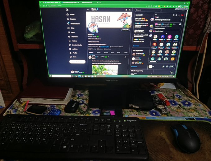 A computer monitor on a desk displays a Twitter/X page for 'HASAN' (@HasanAbi), with a Logitech keyboard and mouse visible on the desk.