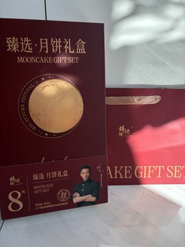 Two dark red boxes of '臻选·月饼礼盒 MOONCAKE GIFT SET' are displayed, featuring a gold moon emblem and a number '8' on the front.