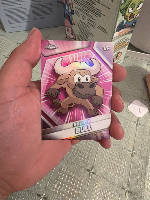 A hand holds a holographic trading card featuring an animated bull character labeled 'BULLISH BULL' with a 'VF' rating and the code 2020250, from The Chain game.
