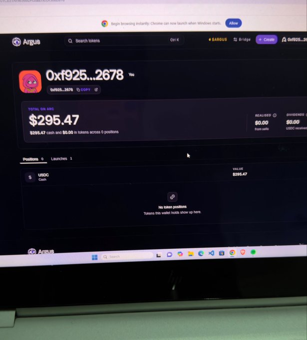 A photograph shows a laptop screen displaying the Argus platform, featuring a token wallet address "0xf925...2678" with a total on Arc balance of $295.47 cash and $0.00 in tokens, showing 1 launch and 0 positions with an empty wallet holding only $295.47 USDC, illustrating the poster's claim of earning free three figures for launching a token on Arc chain overnight.