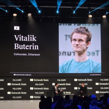 A large screen at a Network State Conference displaying Vitalik Buterin, labeled as Cofounder, Ethereum, in front of an audience.