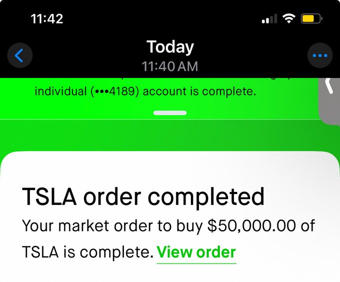 A Robinhood notification confirms a completed market order to buy $50,000 of TSLA at 11:40 AM, which the user humorously frames as leveling up their "dip buying game" by making a large Tesla purchase.