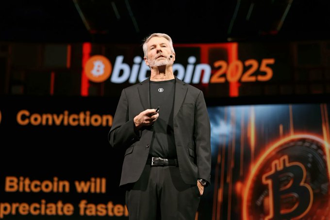 A man speaks on stage at a Bitcoin 2025 conference, with a backdrop displaying "Conviction" and partial text reading "Bitcoin will appreciate faster," alongside a Bitcoin logo.