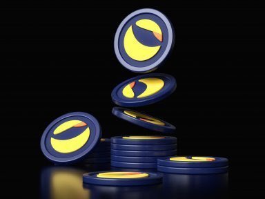 A 3D rendering of blue and yellow LUNC (Terra Luna Classic) cryptocurrency coins stacked and floating against a black background.