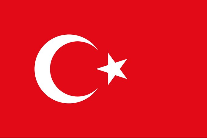 The image features a red flag with a white crescent moon design, which is the main focus of the picture. The background appears to be gray or black, providing contrast to the vibrant colors of the flag. There are no texts present in the image, so we can only see the flag and its details.