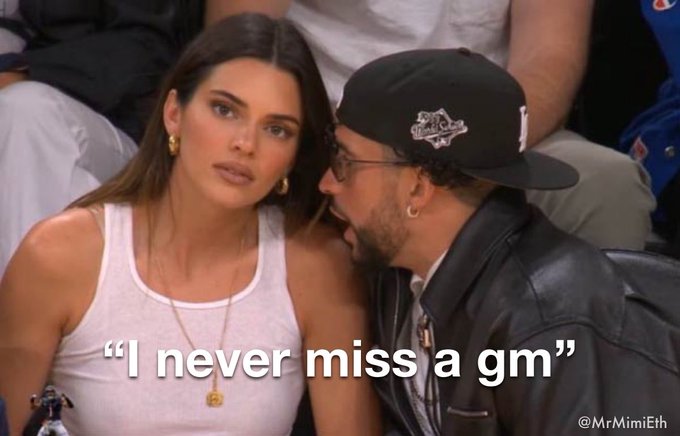 A meme featuring Kendall Jenner and Bad Bunny at a sporting event, with the caption "I never miss a gm" and watermark "@MrMimiEth".