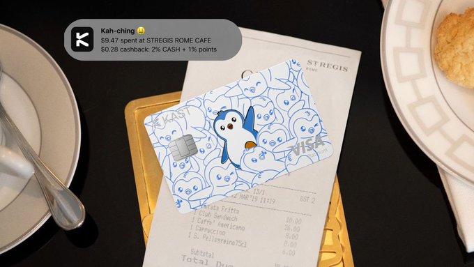 A receipt from St. Regis Rome Cafe totaling $9.47 sits on a table next to plates, topped with a KAST card featuring a cute penguin mascot, while a notification overlay shows "Kah-ching $9.47 spent at STREGIS ROME CAFE" with $0.28 in cashback earned—visually demonstrating how the user funded their dining experience with KAST stablecoins.