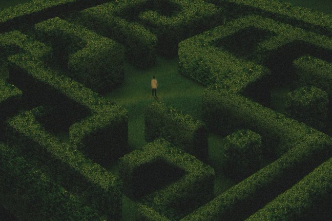 A lone figure stands at the center of a sprawling green hedge maze, dwarfed by the towering walls of foliage that twist and intersect in complex geometric patterns, evoking themes of uncertainty and decision-making that align with the auction-style call to "Bid now" on SuperRare for this digital artwork.