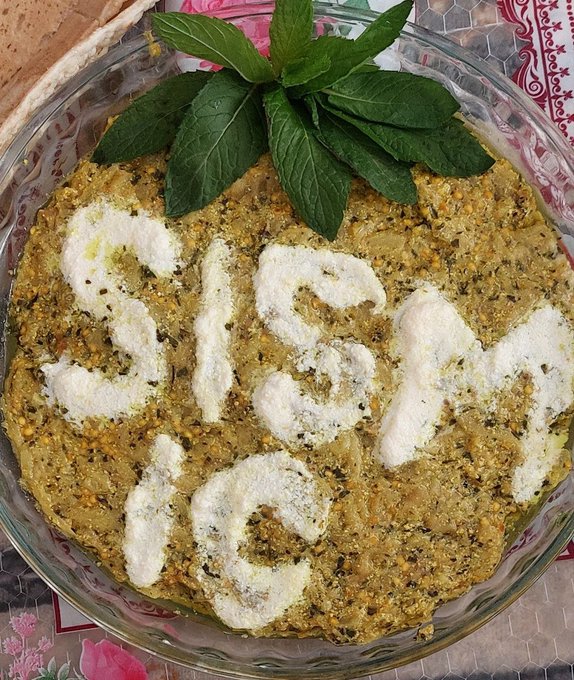 The image features a glass dish filled with food, topped with white cheese and surrounded by green leaves. The dish appears to be a casserole or a similar type of baked dish. The background includes a tablecloth with pink flowers on it. The caption "Seismic" is written in white letters above the dish, which seems to be related to the post about Seismic systems.