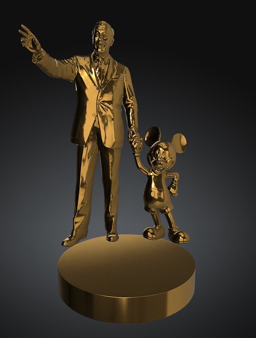 A golden statue of Walt Disney standing on a circular base while holding hands with a small Mickey Mouse figure.
