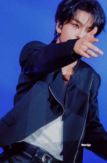 A performer on stage wearing a dark jacket, captioned 'Haochiyu', with an in-ear monitor and stage lighting.