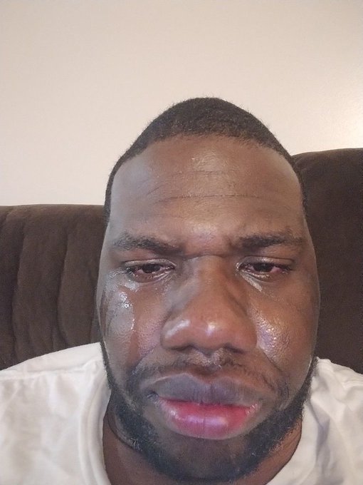 A close-up selfie of a man crying, with visible tears streaming down his face.