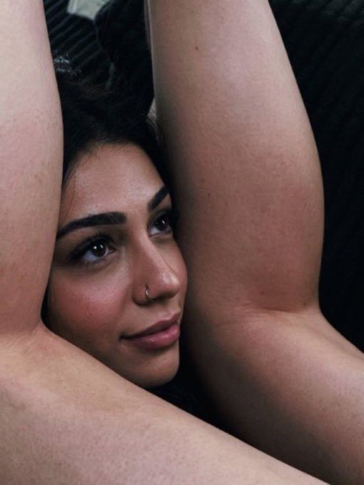 A close-up photo of a woman with dark hair resting her face between her bare legs, gazing intensely at the camera with a subtle smile. The image humorously amplifies the post's caption about the seductive "come-hither" look investors give when finding a low market cap opportunity.