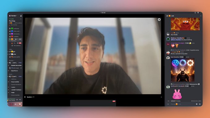 A screenshot of a Discord video call interface showing a smiling man in the main video window with server channels on the left and chat participants on the right.