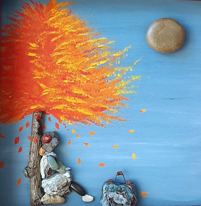 An artistic mixed-media composition on a blue background depicts an autumn tree with bright orange and yellow foliage, a textured golden moon in the upper right, and a small figure seated beneath the tree next to a suitcase, with leaves falling around.