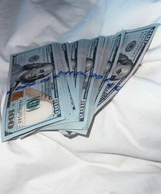 A fan of $100 U.S. bills rests on a white sheet, with a visible serial number (KB 46619619 I) on the top bill, reinforcing the post's theme of wishing for an unexpected financial windfall.