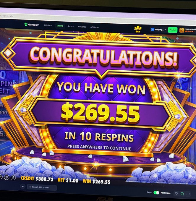 A casino slot machine screen on Gamdom showing 'CONGRATULATIONS! YOU HAVE WON $269.55 IN 10 RESPINS' with credit of $389.73 and bet of $1.00.