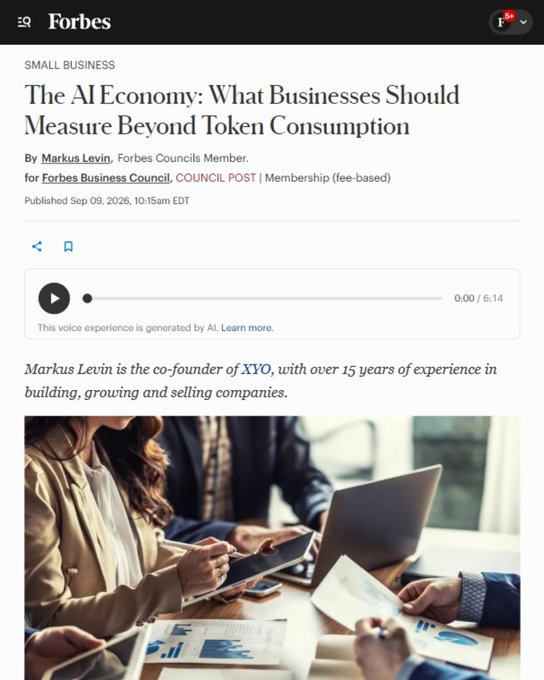 A Forbes article titled "The AI Economy: What Businesses Should Measure Beyond Token Consumption" by Markus Levin, co-founder of XYO, featuring an audio version (0:00/5:14) alongside an image of professionals reviewing business charts and documents, relating to the post's discussion on measuring AI's true business value beyond mere token usage costs.