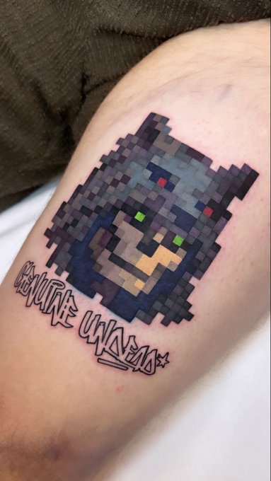 A pixel-art style tattoo on someone's leg depicting a small dog or creature with the text "Evolve Unchained" written below it.