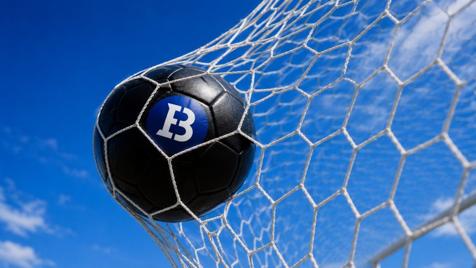The image features a soccer ball, which has the letters "B" and "F" printed on it, flying through the air towards a soccer goal net. The goal net appears to be made of hexagonal mesh material with white lines running across its surface. The background is a clear blue sky with some clouds scattered throughout. The image also includes text that reads "GM. Weekend objective: Touch grass Score goals Stay bullish". This suggests that the image might have been taken during a soccer game or practice session, and the goal net was used to teach players about scoring goals in various weather conditions.