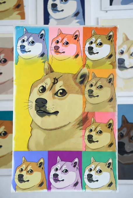 A canvas print featuring a pop art–style collage of the iconic Shiba Inu dog (Doge) is displayed prominently, with similar Doge prints visible in the background, fitting perfectly with the "Dogecoin" theme as the Shiba Inu is the mascot of the cryptocurrency.