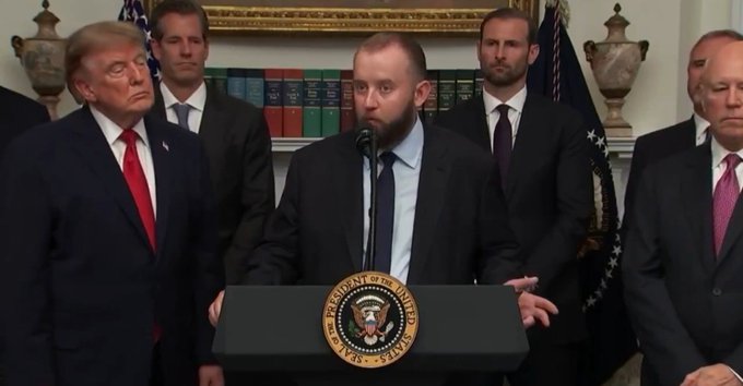 Donald Trump stands to the left of a man speaking at a podium with the Seal of the President of the United States on it, while other men in suits stand behind them. The image likely illustrates a political event or announcement, potentially related to technology or finance given the accompanying post's mention of cryptocurrency and "4IR".
