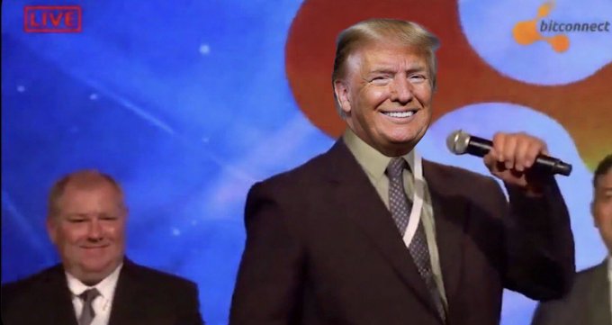 A smiling man in a maroon suit holding a microphone on stage during a 'LIVE' broadcast on 'bitconnect', with another smiling man visible behind him.