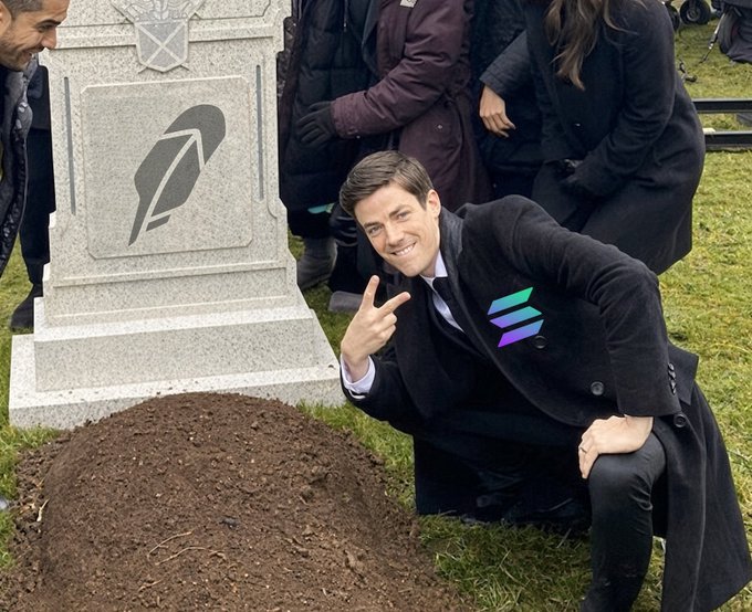A meme image of a smiling man in a suit with the Solana logo on his lapel, taking a selfie next to a gravestone marked with the Rocket Pool (ETH) logo.