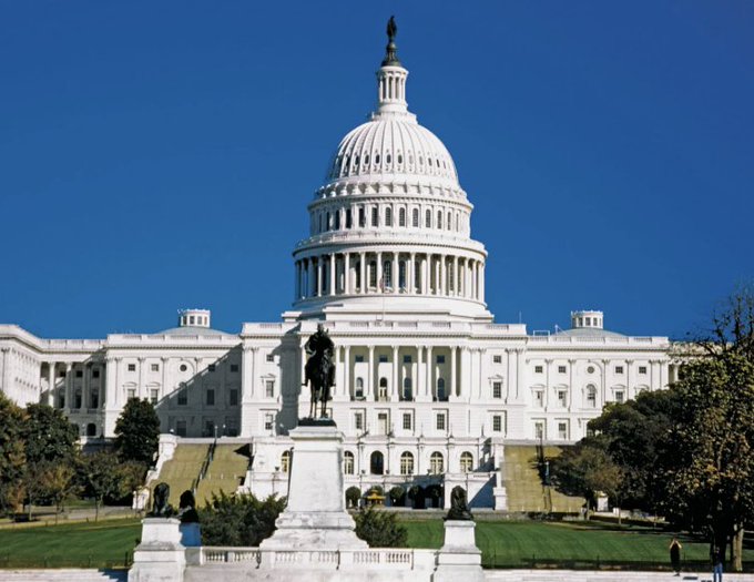 The image shows the United States Capitol Building in Washington, D.C., featuring its iconic white dome and a statue in the foreground. The accompanying post about Senators Tillis and Gallego's revised ethics rules for the CLARITY Act relates to the image as the Capitol represents the legislative body where these senators work and propose such legislation regarding federal token issuance regulation.