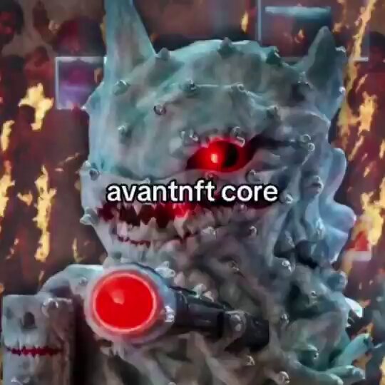 The image features a large, detailed sculpture of a monster with red eyes and teeth, giving it a fierce appearance. The monster has a gun attached to its head, adding to its menacing look. In front of this monster, there is text that reads "avantft core". This suggests that the monster might be part of an avant-futurist project or a futuristic concept.