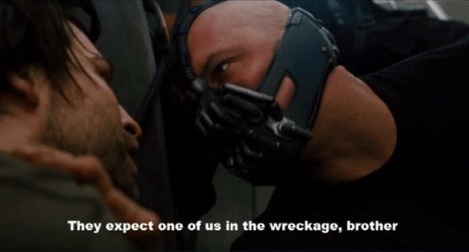 A movie still showing Bane from The Dark Knight holding his mask to another man's face, with the subtitle "They expect one of us in the wreckage, brother".