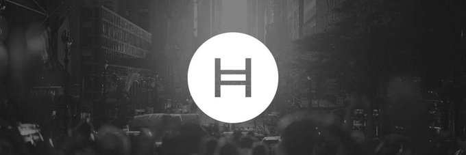 The image features an advertisement for a cryptocurrency called @hedera. The advertisement is displayed against a black background with white text, making it stand out prominently. The logo of the cryptocurrency is also visible within the image. The caption provided below the image explains that the cryptocurrency operates in a global sponsorship layer where finance, engineering, and enterprise marketing intersect. This positioning makes the @hedera brand more structural than promotional.