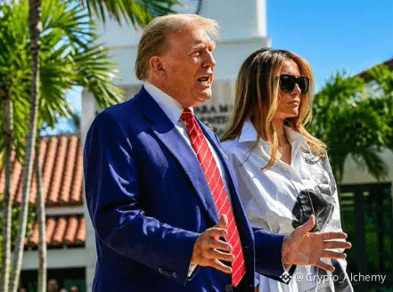 A photograph of Donald Trump in a blue suit and red tie walking alongside Melania Trump in a white dress, watermarked with the Crypto Alchemy logo.