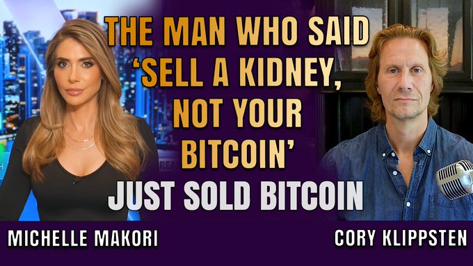 The image features a poster with two people, one woman and one man, sitting behind microphones. The text on the poster reads "The man who said 'sell a kidney, not your bit coin'". This quote seems to be related to Bitcoin or cryptocurrency discussions.