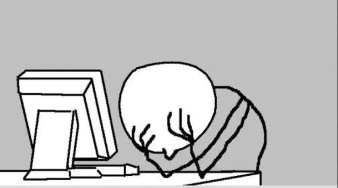 A minimalist black and white line drawing meme depicting a figure sitting at a desk with their head buried in their hands in front of a computer monitor, conveying frustration or despair.