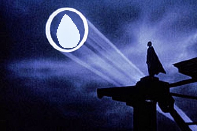 A moody, blue-toned scene shows a cloaked figure standing on a rooftop structure shining a beam of light into the sky, illuminating a large circular emblem containing a white droplet shape.