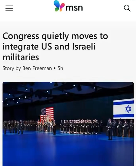 The image shows a group of people standing together, possibly at an event or gathering. The text on the screen reads " Congress Quietly Moves To Integrate US And Israeli Militariaries", which suggests that there might be some sort of discussion or decision related to military integration between the United States and Israel.