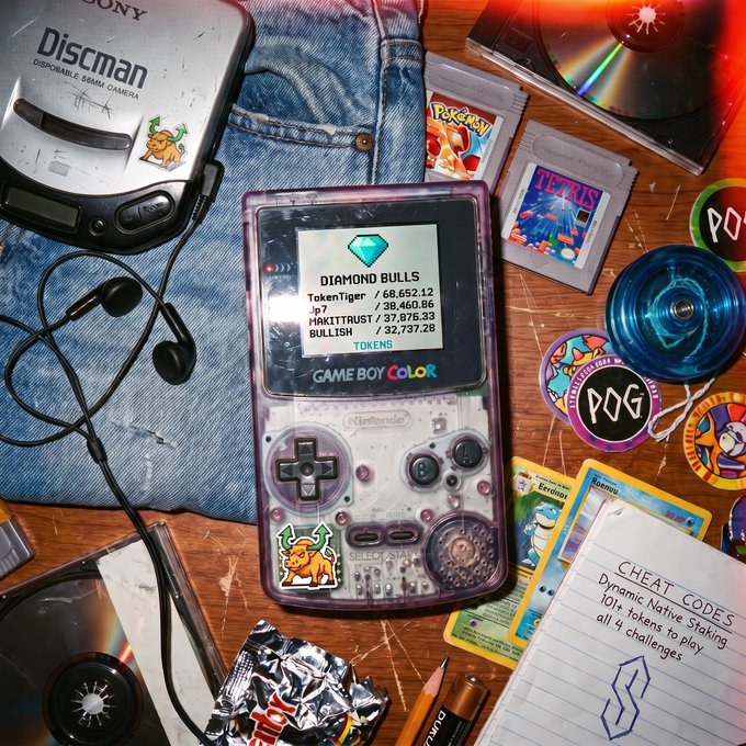 A nostalgic flat lay features a transparent Game Boy Color displaying a 'DIAMOND BULLS' token leaderboard, surrounded by a Sony Discman, Pokémon and Tetris cartridges, Pokémon cards, yo-yos, and a notepad listing 'CHEAT CODES.'