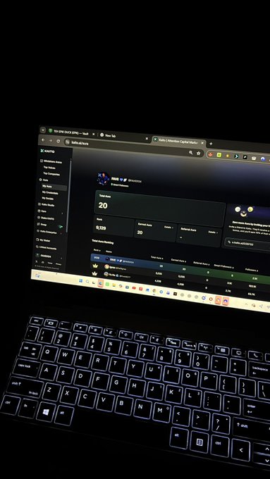 A photo of a laptop in a dark room displaying the Robinhood Chain analytics page, with the keyboard visible in the foreground.