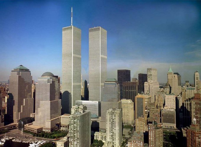 The image shows the pre-9/11 World Trade Center Twin Towers towering over the Lower Manhattan skyline on a clear day, a stark visual reference to the post's mention of a potential 9/11-related "token runner" in cryptocurrency markets, as the original towers' destruction remains a significant historical event that some crypto projects exploit for attention.