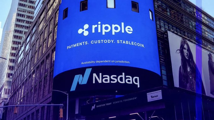 A large digital billboard in what appears to be Times Square displays a prominent advertisement for "Ripple" with the tagline "Payments. Custody. Stablecoin." and the "Nasdaq" logo below it, directly tying to the breaking news that Ripple-backed Evernorth Holdings is advancing its Nasdaq listing. The backdrop of towering skyscrapers and additional billboards reinforces the major financial milestone being announced.