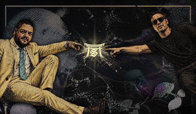 Two men strike dramatic pointing poses toward a glowing "JS" logo at the center, with the post's "GM GM" (good morning) greeting complementing the bold, energetic promotional graphic.