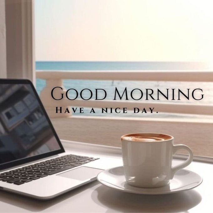 A 'Good Morning, have a nice day' greeting image featuring a cup of coffee on a saucer next to a laptop on a table, with an ocean view in the background.