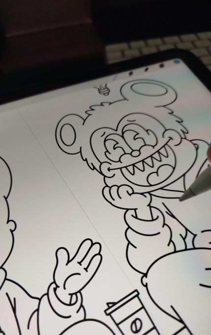 A digital tablet screen shows a black-and-white line drawing of a cartoon monster with sharp teeth, being traced over with a stylus pen.
