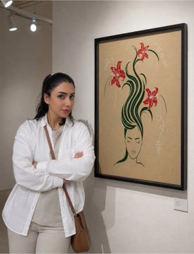 A woman with crossed arms stands in a gallery next to a framed botanical-style artwork depicting a woman's face with flowers growing from her head.