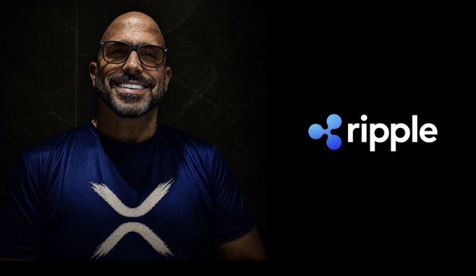 A promotional image showing a smiling man with glasses wearing an XRP/Ripple shirt, alongside the Ripple logo on a dark background.